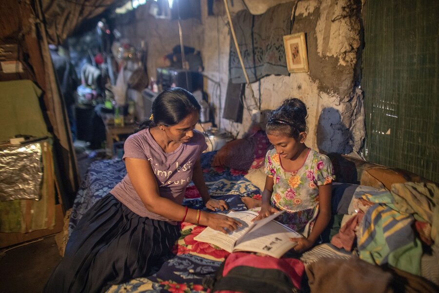 A mother reads a book with her child at their home in Sri Lanka