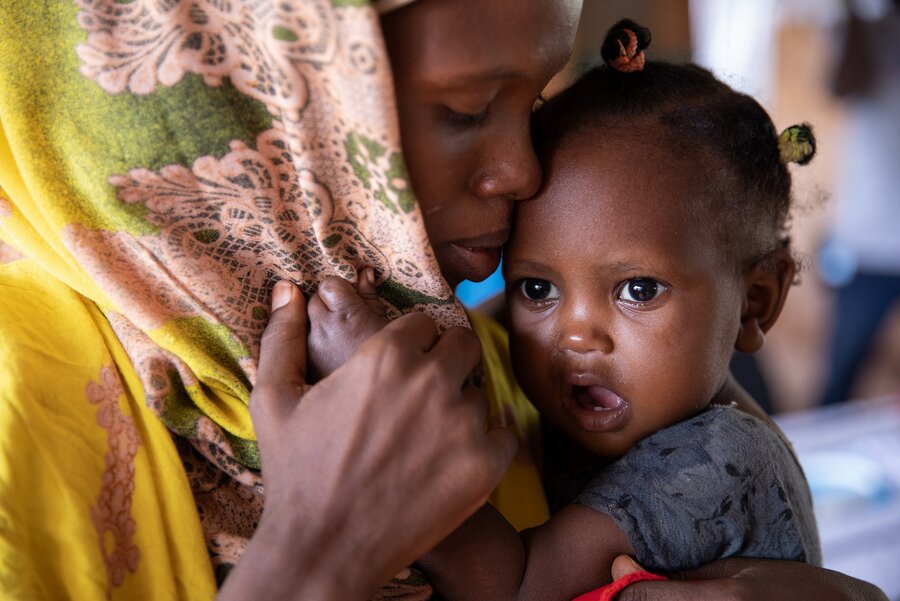 A mother holds her baby daughter close to her face