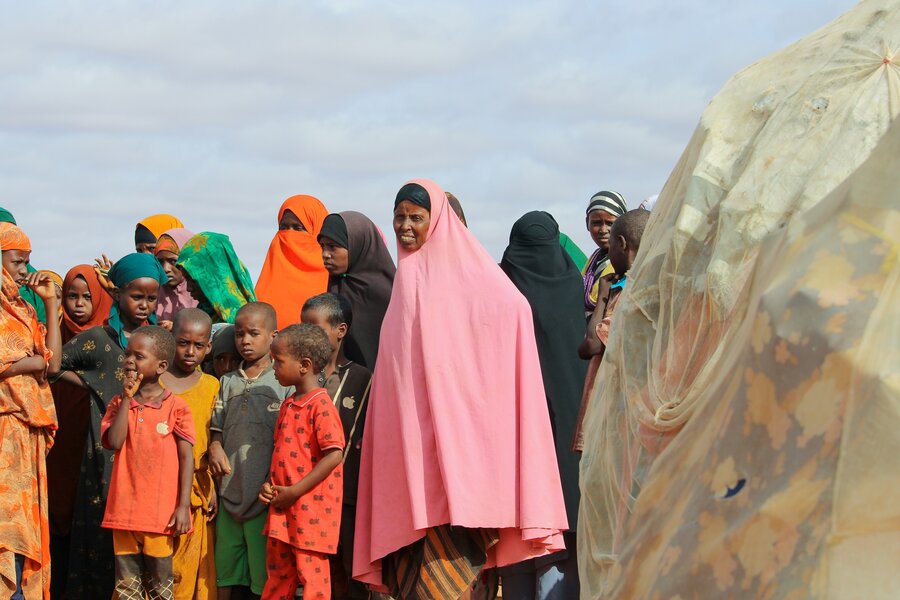 Women and children crowd together in a refugee camp