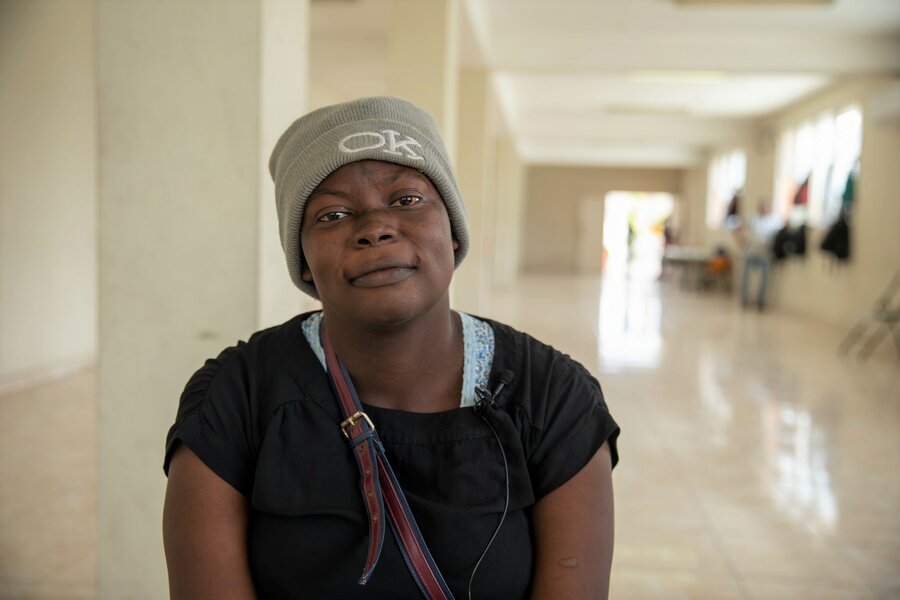 A woman wearing a beanie stares into the camera