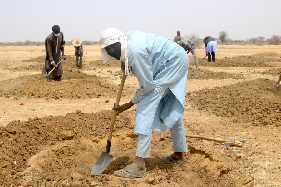 Man digging into ground with spade