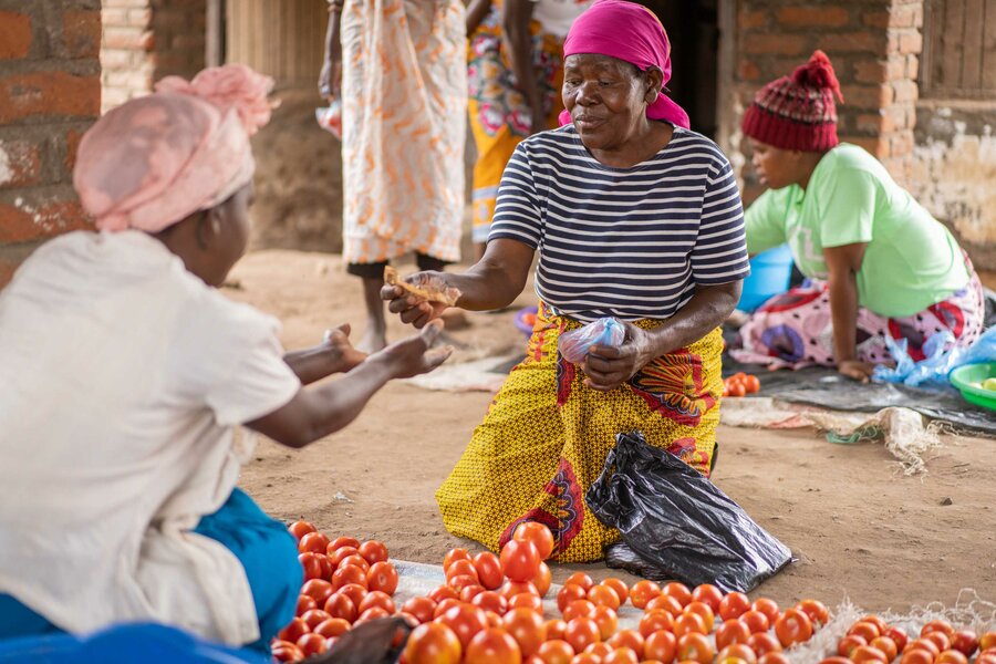 woman paying for vegetables at a market