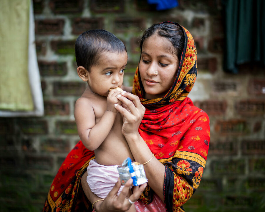 Bangladesh: Zakia and her 2-year-old daughter Shimu with fortified biscuits provided by WFP, after their home was flooded. Photo: WFP/Sayed Asif Mahmud