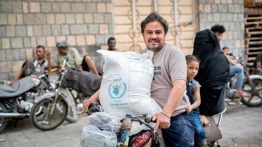 In Hodeida governorate, Ahlah, 9, and her dad head home with WFP food rations. Photo: WFP/Mohammed Awadh