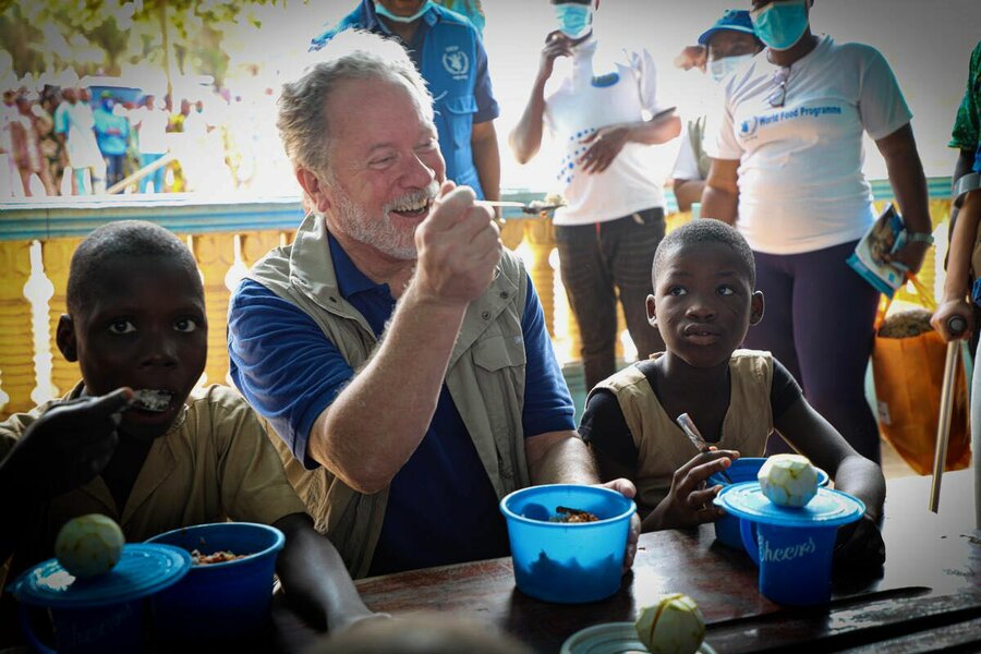 WFP Executive Director David Beasley shares a meal with school kids in Benin. WFP/Richard Mbouet