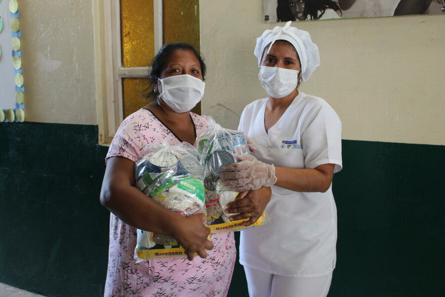 A mother collects take-home rations distributed to vulnerable pupils during the COVID-19 pandemic by WFP and local authorities in Colombia's La Guajira department. Photo: WFP/Miller Choles