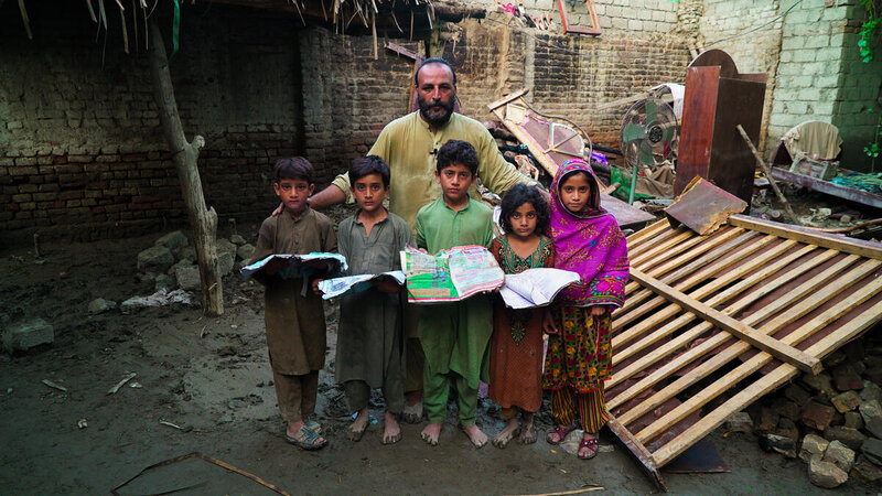 Saeed Jan and his five children salvaging books from their destroyed home. Haris Khalid