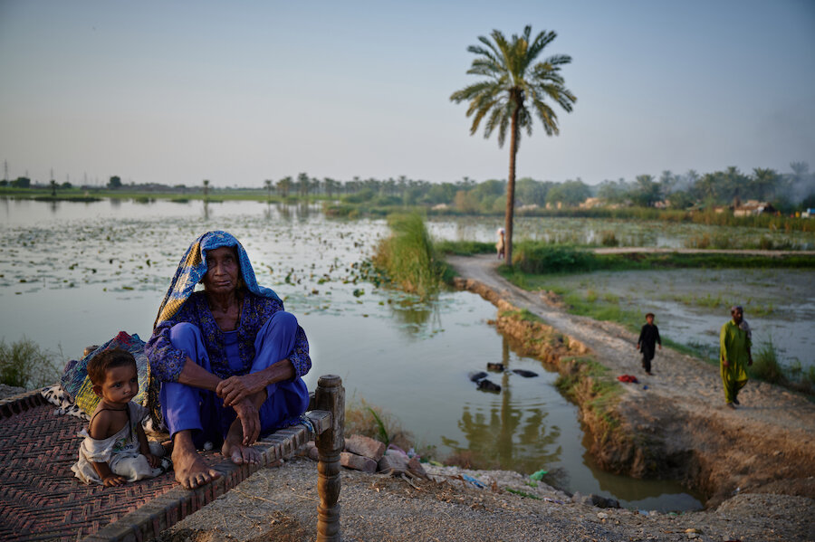 Woman and child sat near flood waters