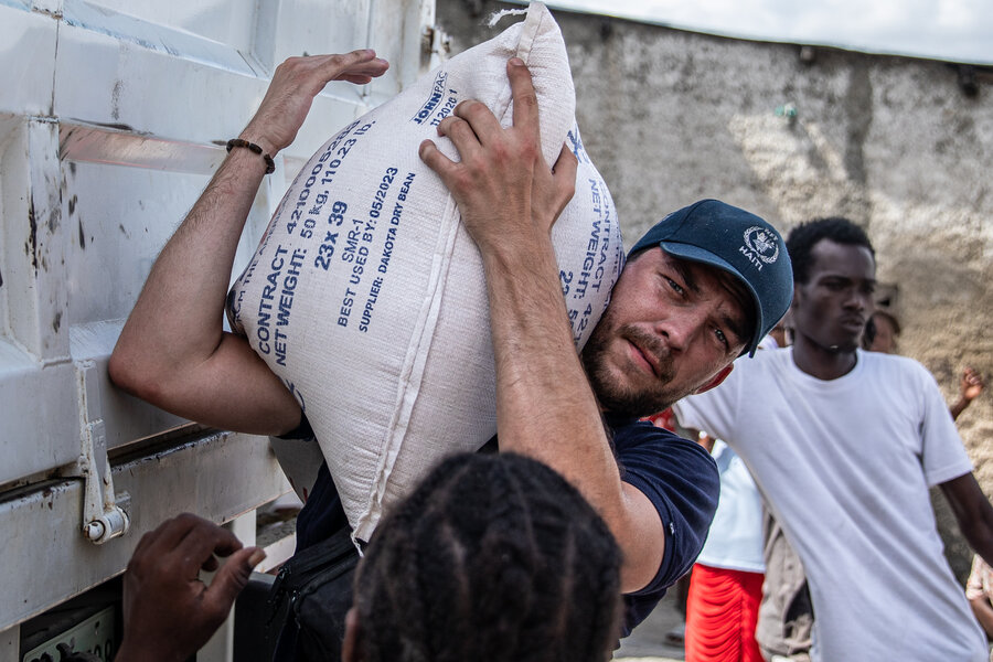 A man carries WFP food in Port-au-Prince neighbourhood of Cite Soleil. WFP Theresa Piorr