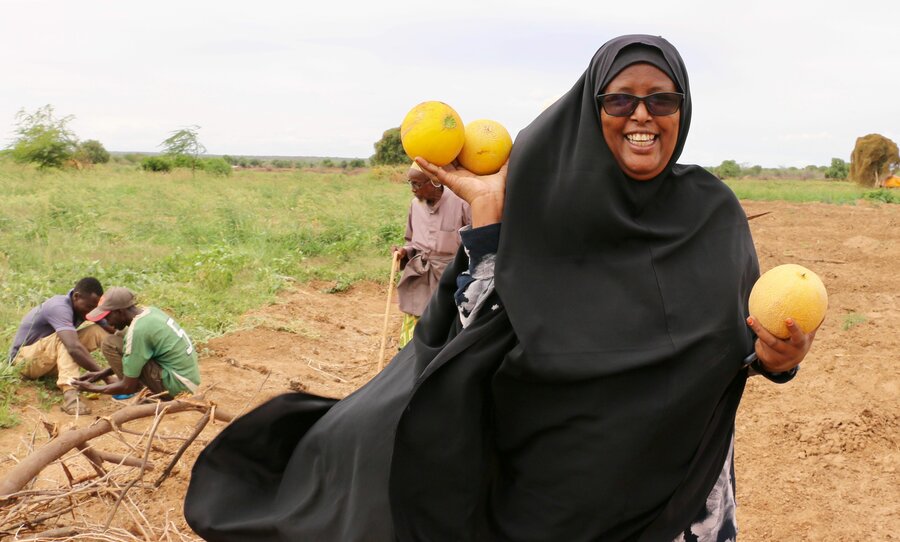 Farmers' group secretary Amina Issa proudly displays her harvest. Photo: WFP/Martin Karimi