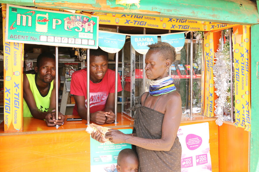 Alice collecting her cash at the local MPESA shop