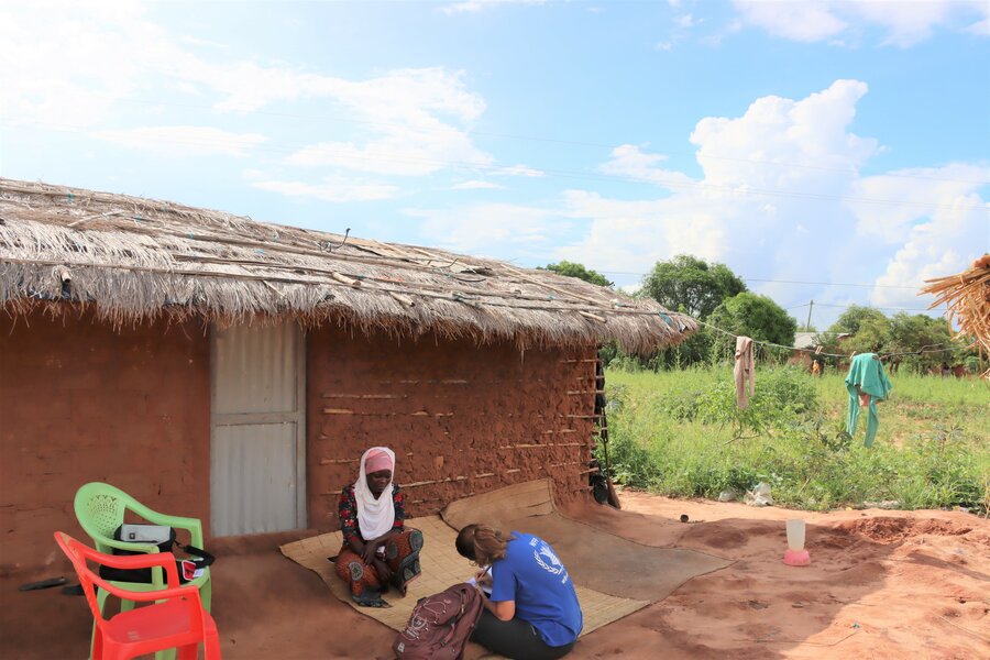 Salome outside her home speaking to WFP's Denise Coletta. Photo: WFP/Narcia Walle