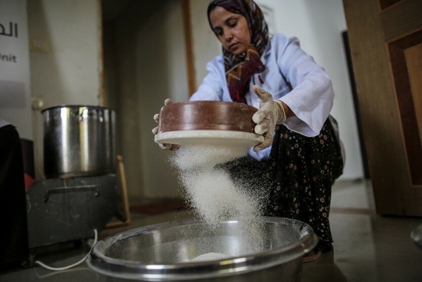 Sahar is sifting wheat flour to make Maftoul. Photo: WFP/Ali Jadallah