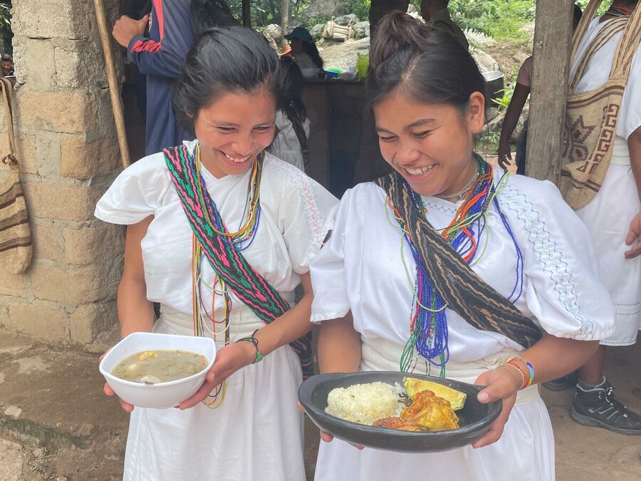 Two Arhuaco women in Pueblo Bello, Cesar department, in Colombia, take food made of ingredients grown in a WFP-backed vegetable garden belonging to the Kwanimun community. Photo: WFP/Paola Campos