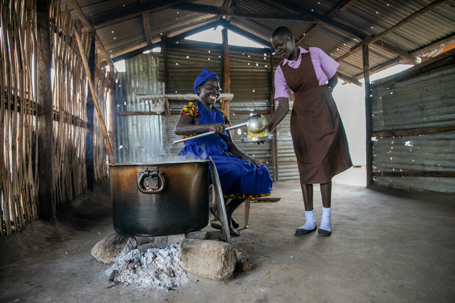 The cook serves lunch to a school girl