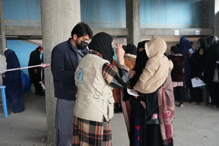 A woman and her child receive WFP food assistance in Kabul province. Women and girls have been hardest hit by Afghanistan's hunger crisis. Photo: WFP/Sadeq Naseri