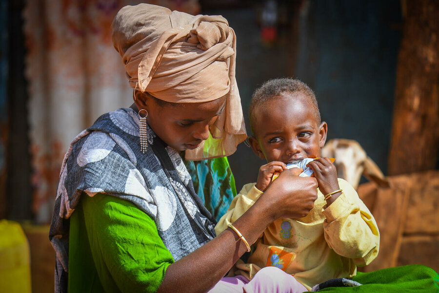 Liben Kefela receives WFP-supported nutrition-packed Plump'Sup from his mom Shedole. Photo: WFP/Michael Tewelde