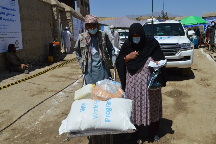 Fifty-year-old widow Guldana (R) carts home WFP food for her family. Photo: WFP/Ziauddin Safi