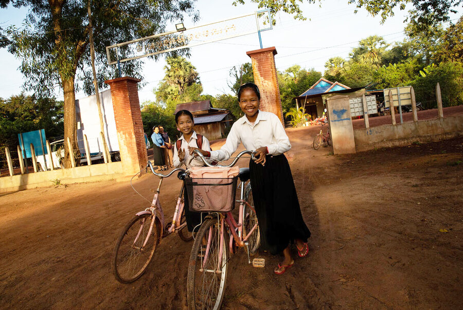 Ouy Heng (r) and her sister takes their bicycles to school at Siem Reap