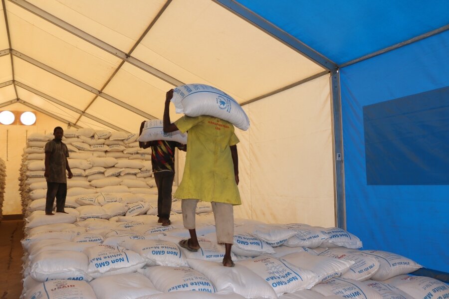 Workers stack bags of maize at a WFP warehouse at Dadaab. WFP's food assistance has been cut for lack of funds. Photo: WFP/Martin Karimi