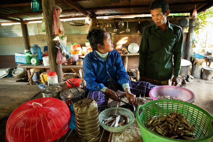  (Required) In this photo Phat No (48) prepares fish for lunch, and to be fermented for later, at her home in Sambour commune, near Kampong Thom. Her husband Deur Sol (52) watches on.