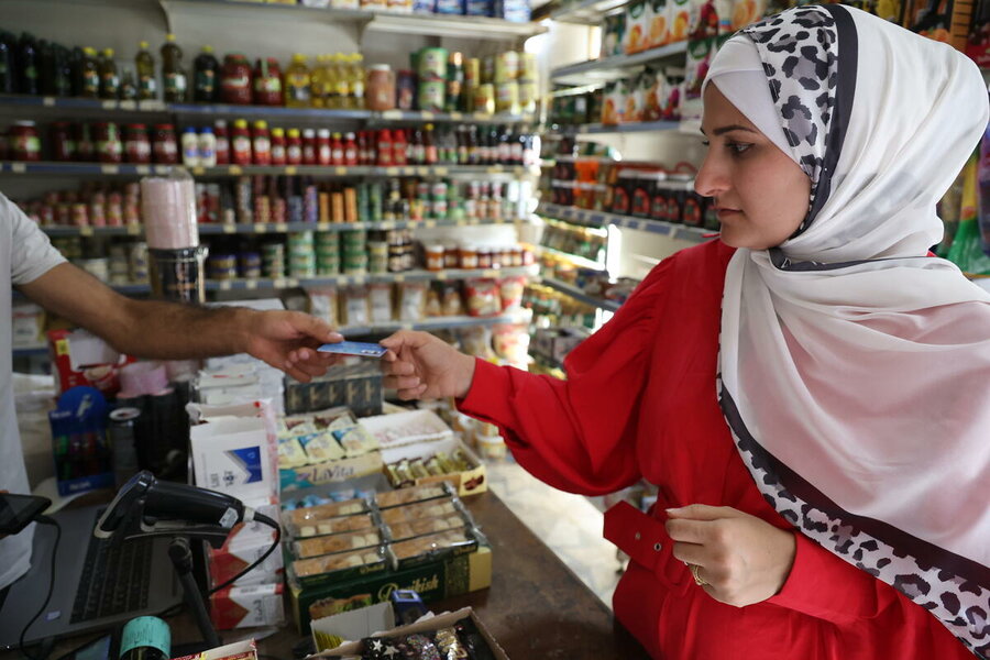 In Deir Azzor, Syria, Salwa receives cash assistance in the form of an e-voucher from WFP. Photo: WFP/Hussam Al Saleh