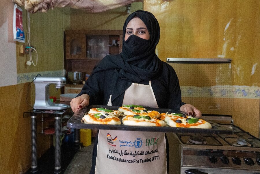 Liza shows off her mini-pizzas, hot from the oven. Photo: WFP/Mehedi Rahman