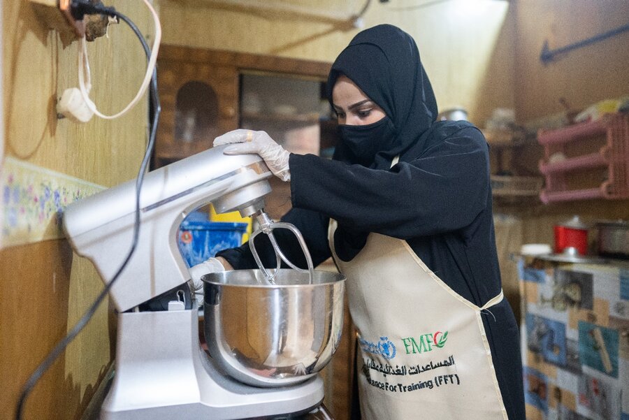 Liza mixes pizza dough at her kitchen in Aden. Photo: WFP/Mehedi Rahman