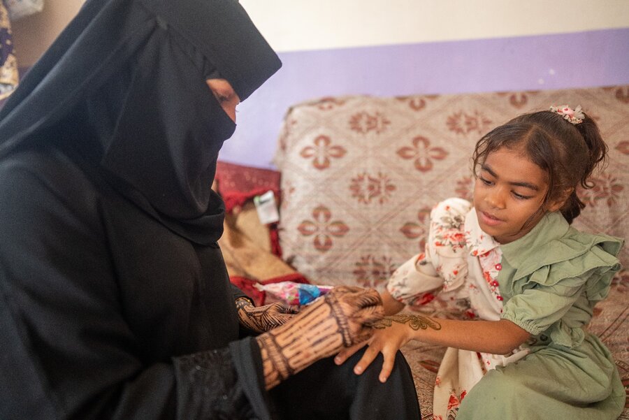 Omnia applies her artistry on a young neighbour. Photo: WFP/Mehedi Rahman