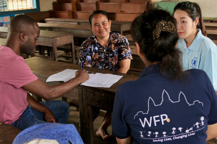 WFP staff interview Seng as part of routine monitoring to ensure high standards are met at her school. Photo: WFP/Edward Johnson
