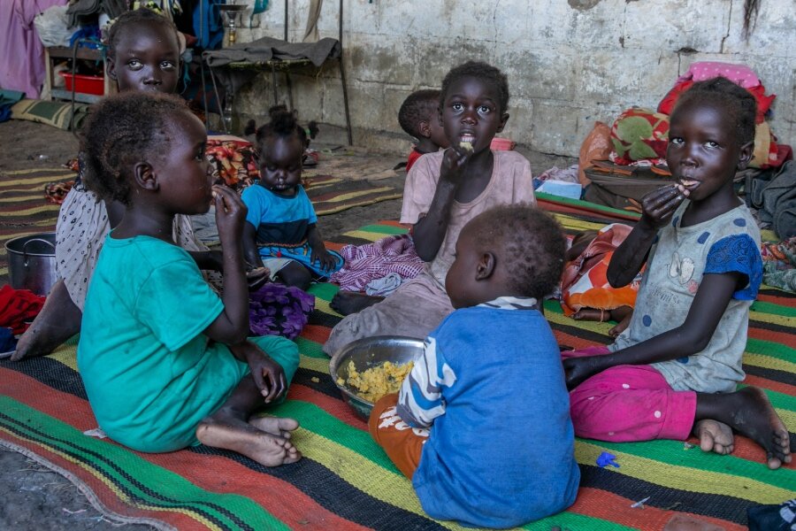 Aker's children tuck into a simple meal made with WFP pulses. Photo: WFP/Eulalia Berlanga