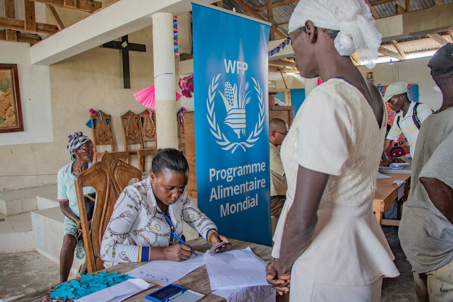 A woman receives WFP cash assistance in Port de Paix, Haiti. We have been forced to sharply reduce our assistance due to funding cuts. Photo: WFP/Luc Segur