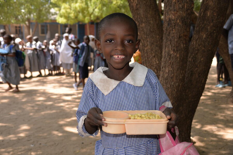 WFP's hot school meal puts a smile on Binja Mnaegabe's face at Kenya's Kakuma refugee camp. The meals help keep girls and boys in school, allowing them better life choices. Photo: WFP/Rose Ogala