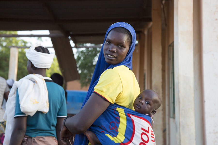 A woman waits, with her baby on her back, to be registered for WFP assistance in  in Kaya, north of Ouagadougou, Burkina Faso.