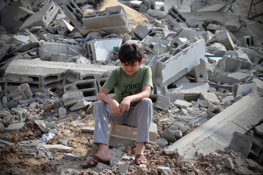 A child sat among rubble