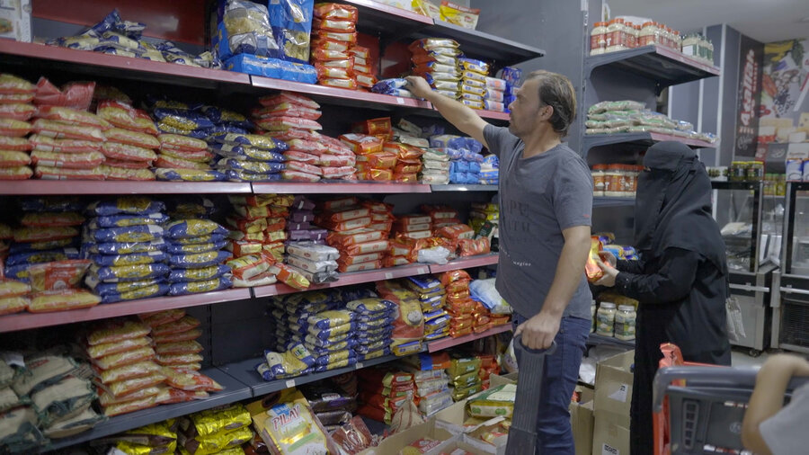 A man taking groceries from a store shelf