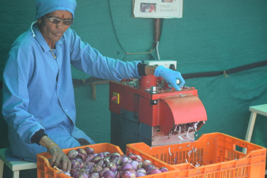 Chayya, a microentrepreneur processes onions to sell on