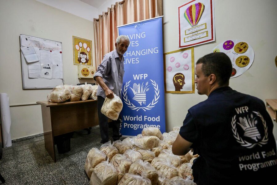 GAZA_A man receives WFP bread at an emergency shelter WFP Ali-Jadallah