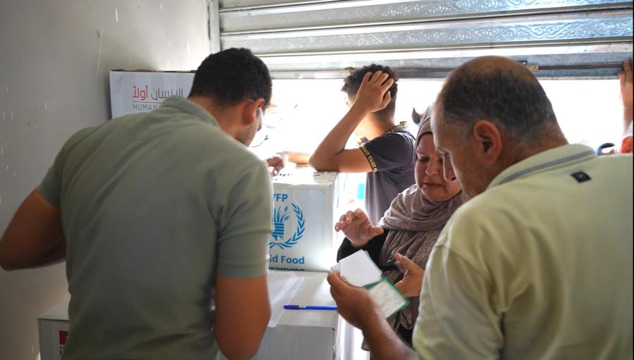 A woman receives assistance at a WFP distribution point in Gaza
