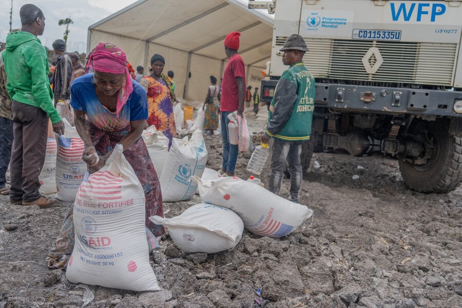 I DRCs Nord-Kivu-provins samler en kvinne inn mat fra WFP støttet av USA og andre givere.  Mat og kontanthjelp reduserer risikoen kvinner kan møte når de prøver å forsørge familiene sine.  Foto: WFP/Michael Castofas