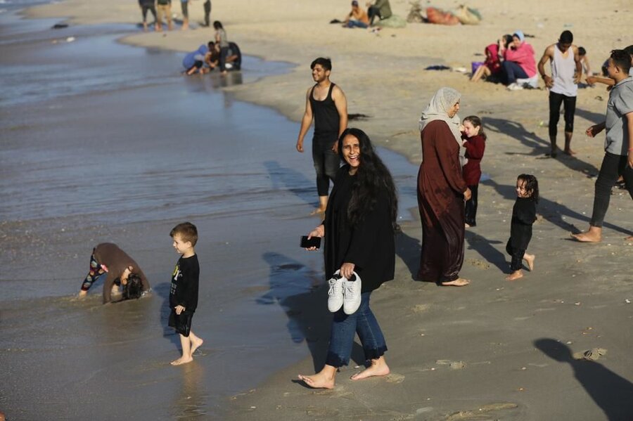 barefoot families on the shore of Gaza during humanitarian pause