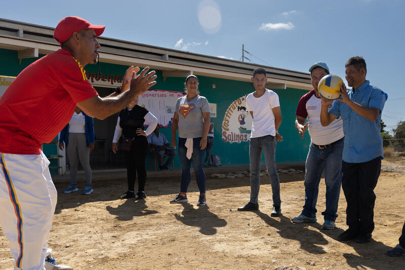 a group of people with disabilities play ball in a school yard in Venezuela