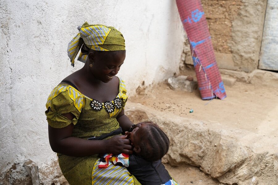 Chrisitina — an internally displaced person, with one of her children in the courtyard of the house where she and her family have found refuge.