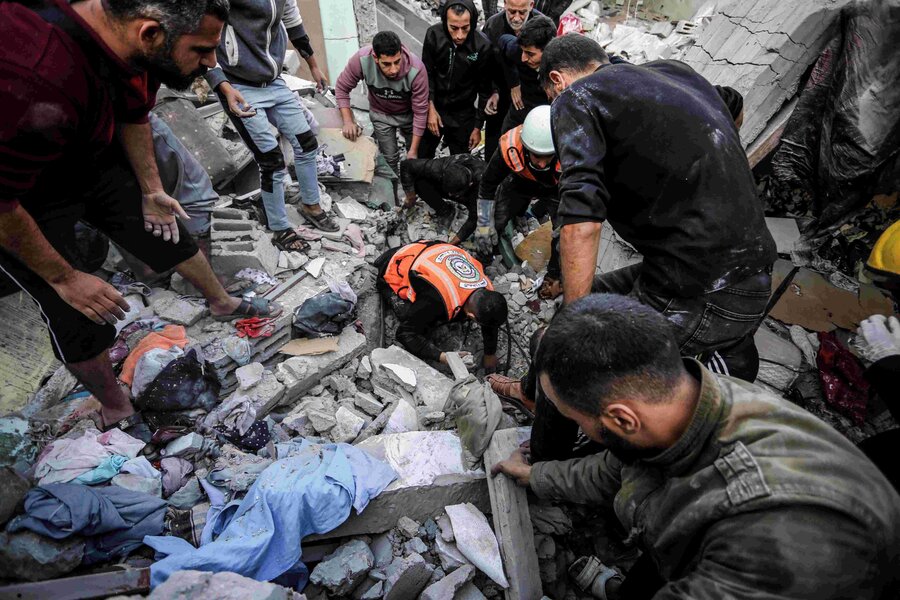 Palestine. Aid workers and men go through the rubble to save lives