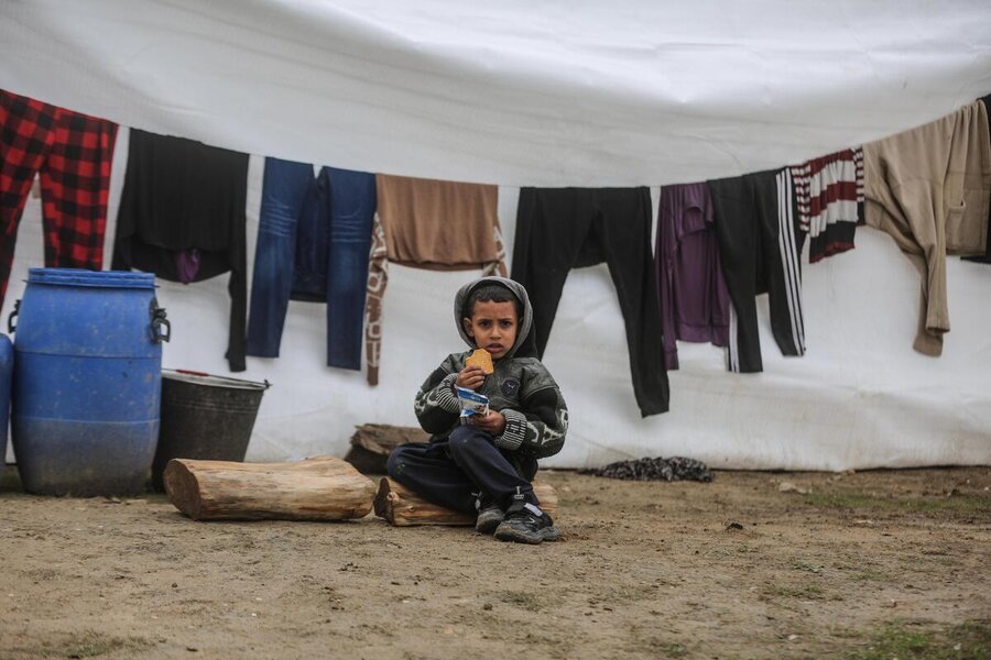 A boy takes a fortified WFP biscuit at a camp for displaced people in southern Gaza. Photo: WFP/Ali Jadallah