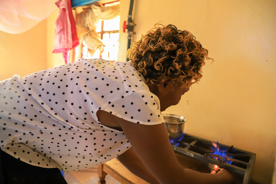 Kenyan farmer Alpina Korogen lights up her new biogas-powered stove. Photo: WFP/Martin Karimi