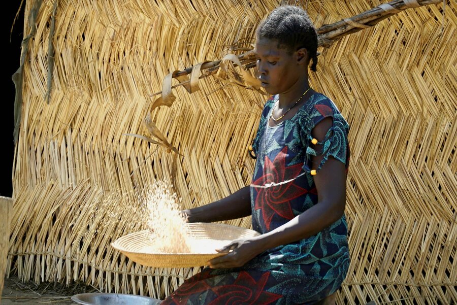 Nyandeng Noon removes husks from her rice harvest before cooking it for her children. Photo: WFP/Musa Mahadi