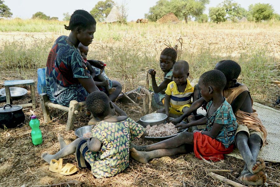 Noon's children tuck into the rice she has harvested from the WFP resilience-building project. Photo: WFP/Musa Mahadi