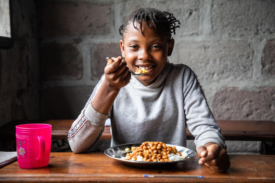 A girl at a school in Kinshasa in the Democratic Republic of Congo takes a plate of beans. Photo: Vincent Tremeau