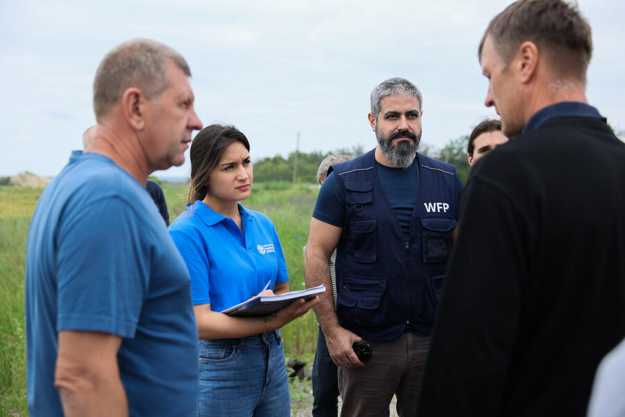 Workers from WFP and FAO, along with Swiss deminers, speak with Ukrainians to assess the situation on the ground ahead of clearing landmines. Photo: WFP/Anastasiia Honcharuk
